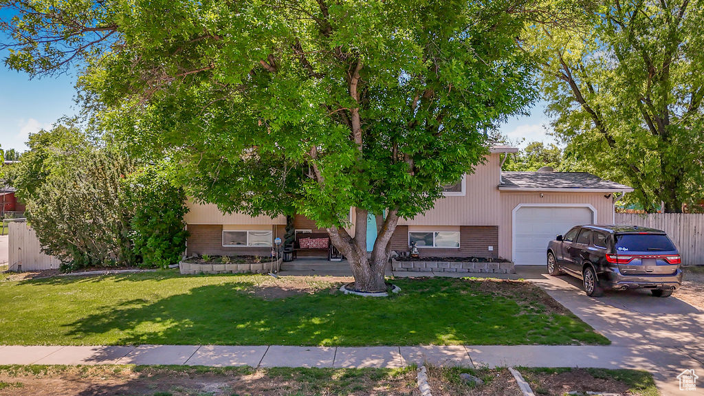 View of front of home with an attached garage, brick siding, and concrete driveway