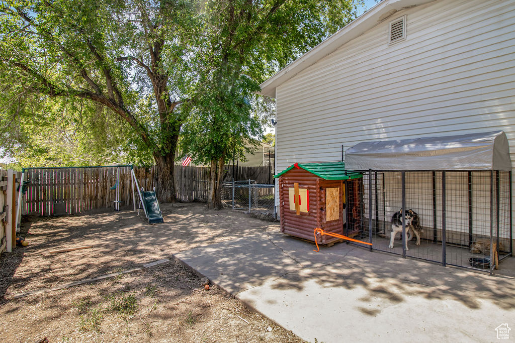 Fenced backyard featuring a playground