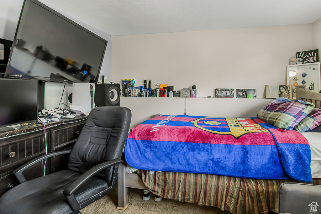 Bedroom with carpet flooring and an office area