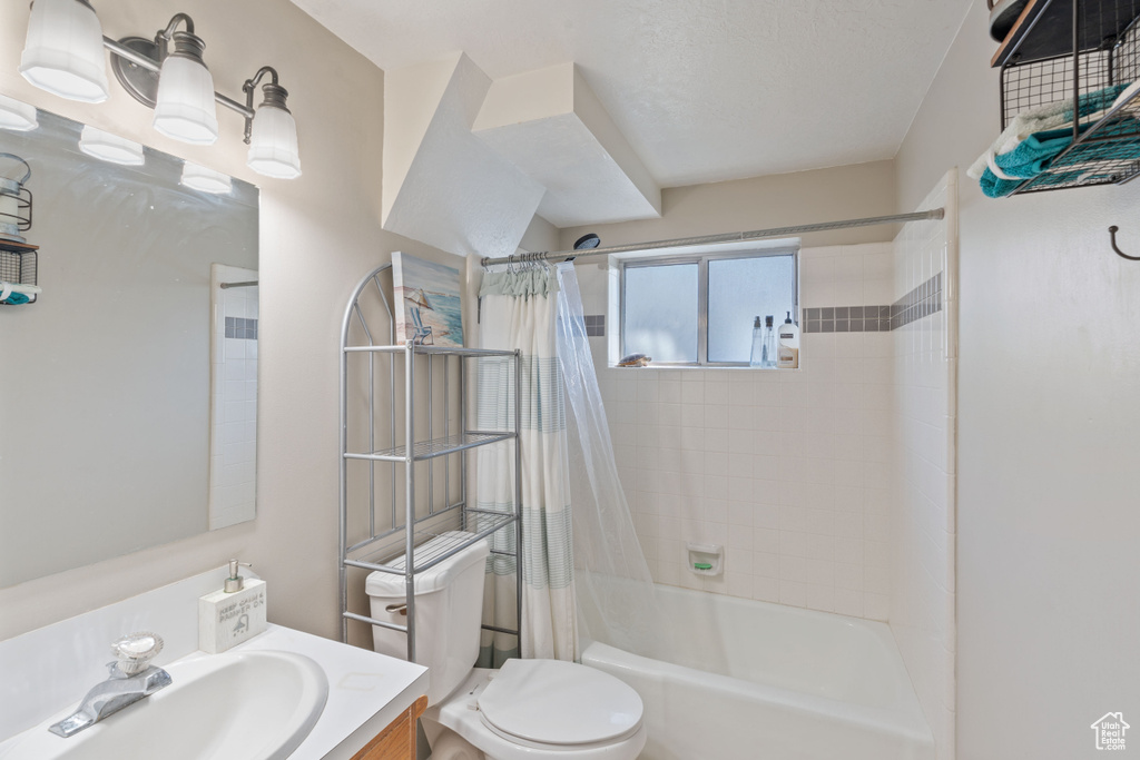 Full bathroom with shower / bath combination with curtain, vanity, and toilet