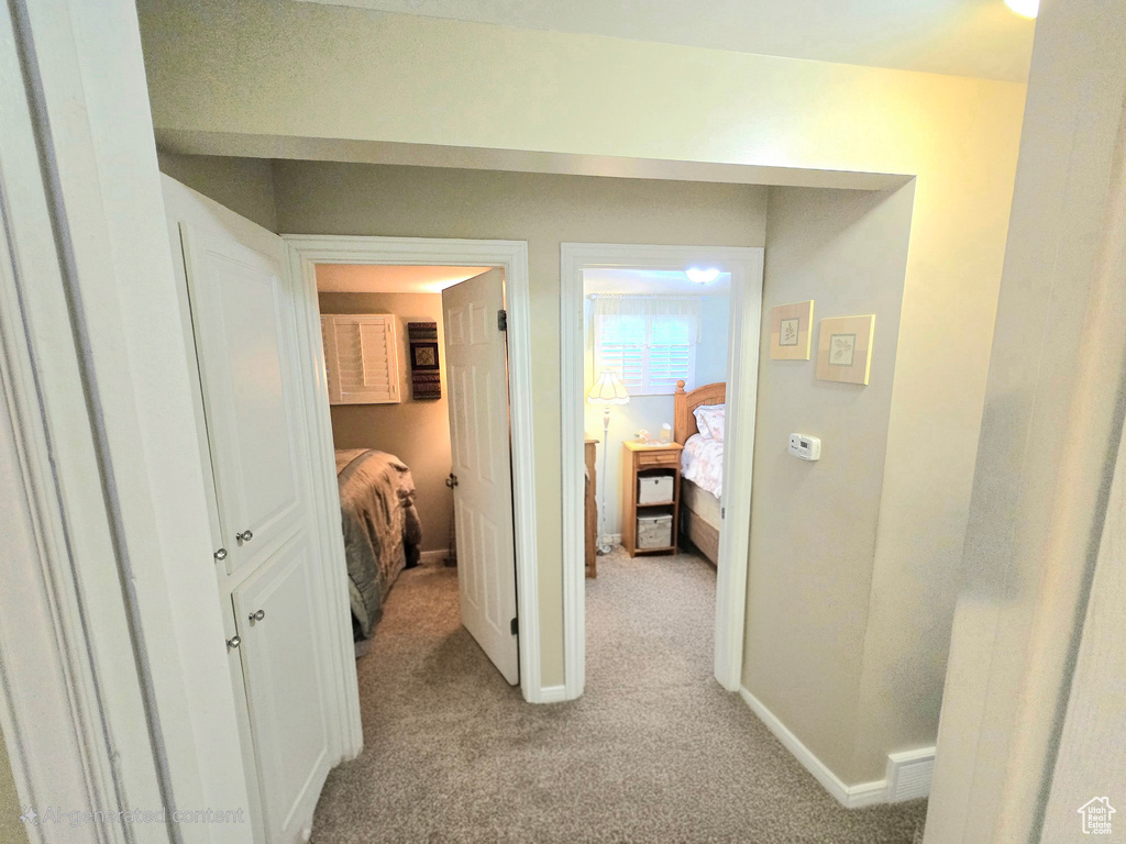 Hall featuring light carpet and baseboards