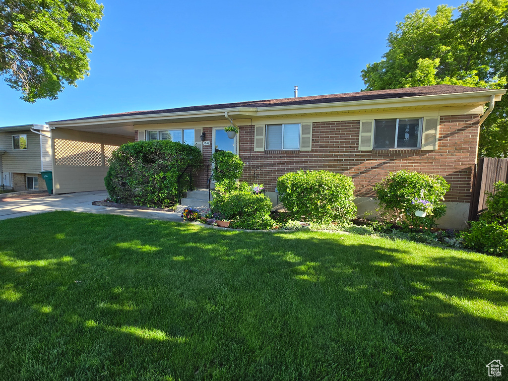 Ranch-style house featuring brick siding and a front lawn