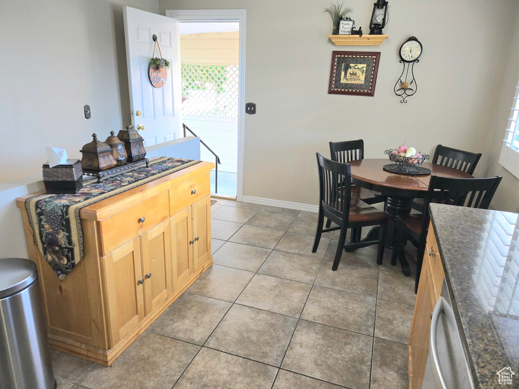 Dining area featuring light tile patterned floors, healthy amount of natural light, and baseboards