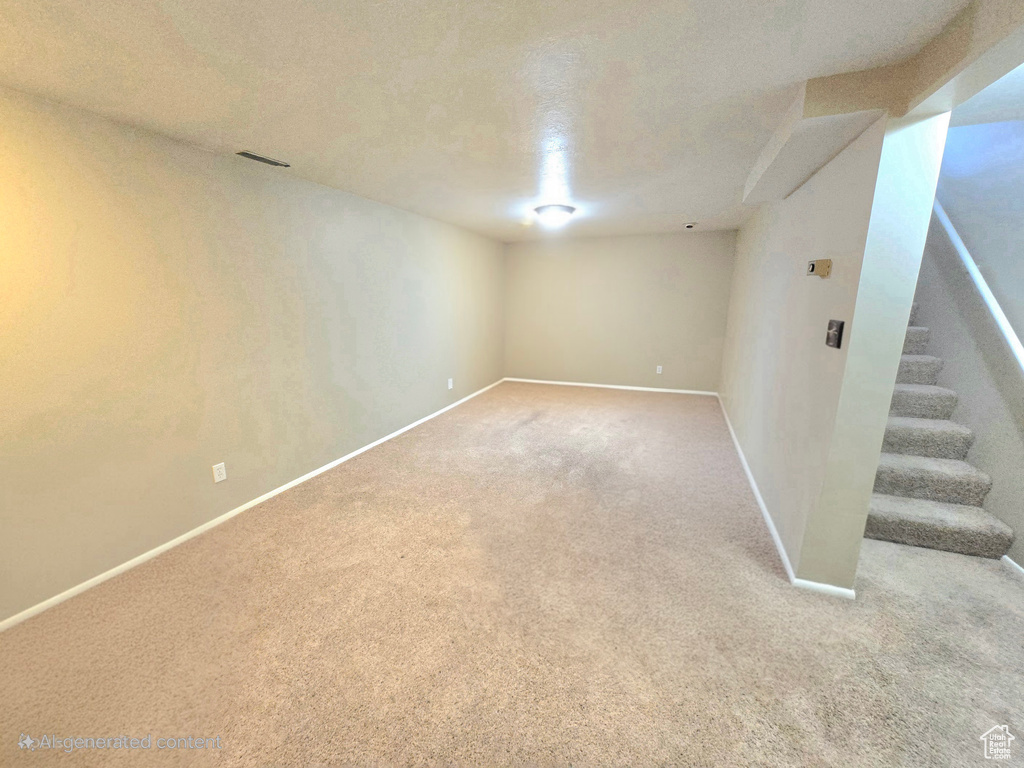 Finished basement featuring carpet, stairs, and baseboards