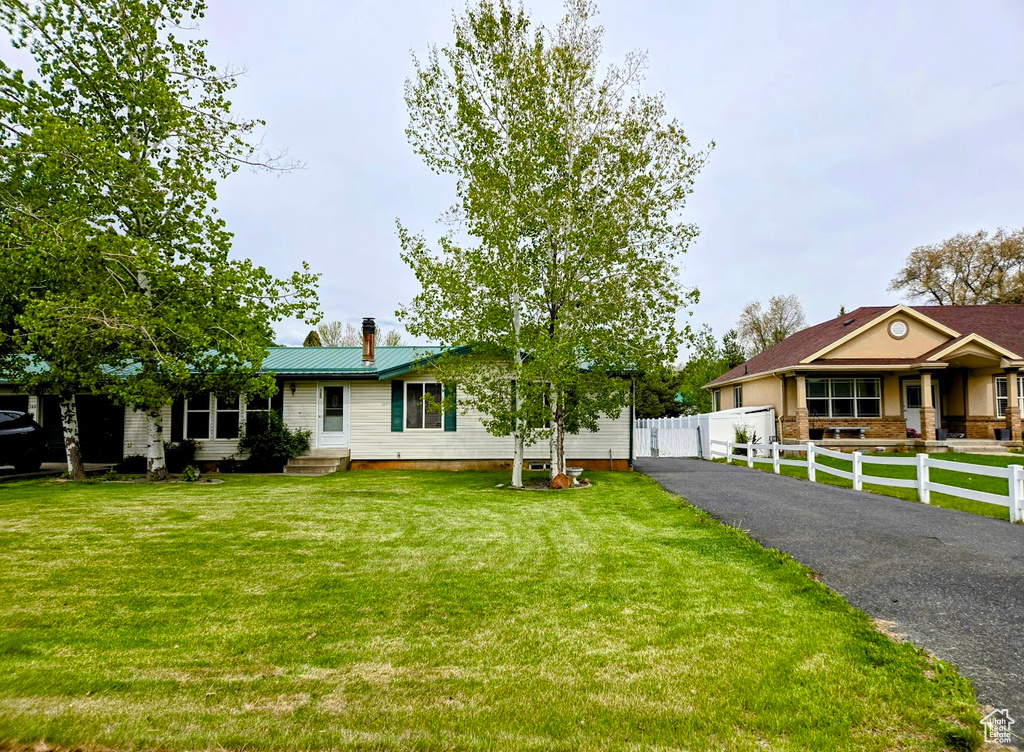 Ranch-style home featuring a chimney, metal roof, and entry steps