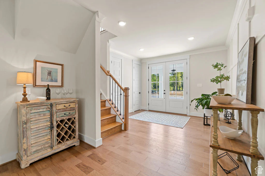 Entrance foyer with stairway, baseboards, light wood finished floors, crown molding, and recessed lighting