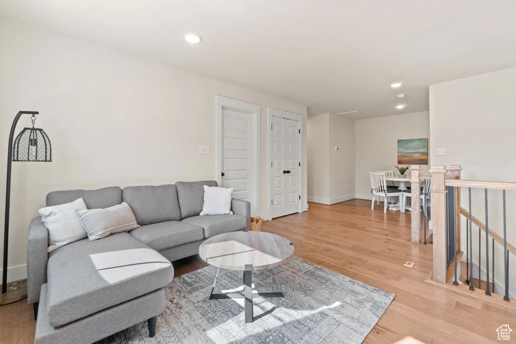 Living room featuring light wood-style floors, recessed lighting, and baseboards