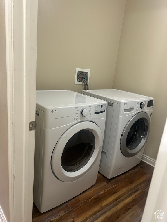 Laundry area featuring washing machine and dryer and dark wood-type flooring