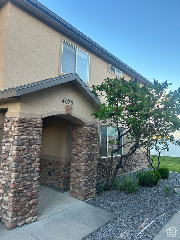 Entrance to property with stucco siding and stone siding