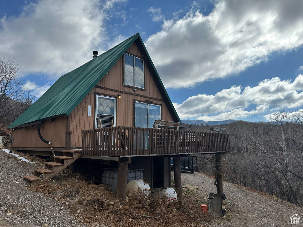 Back of property featuring a deck and metal roof