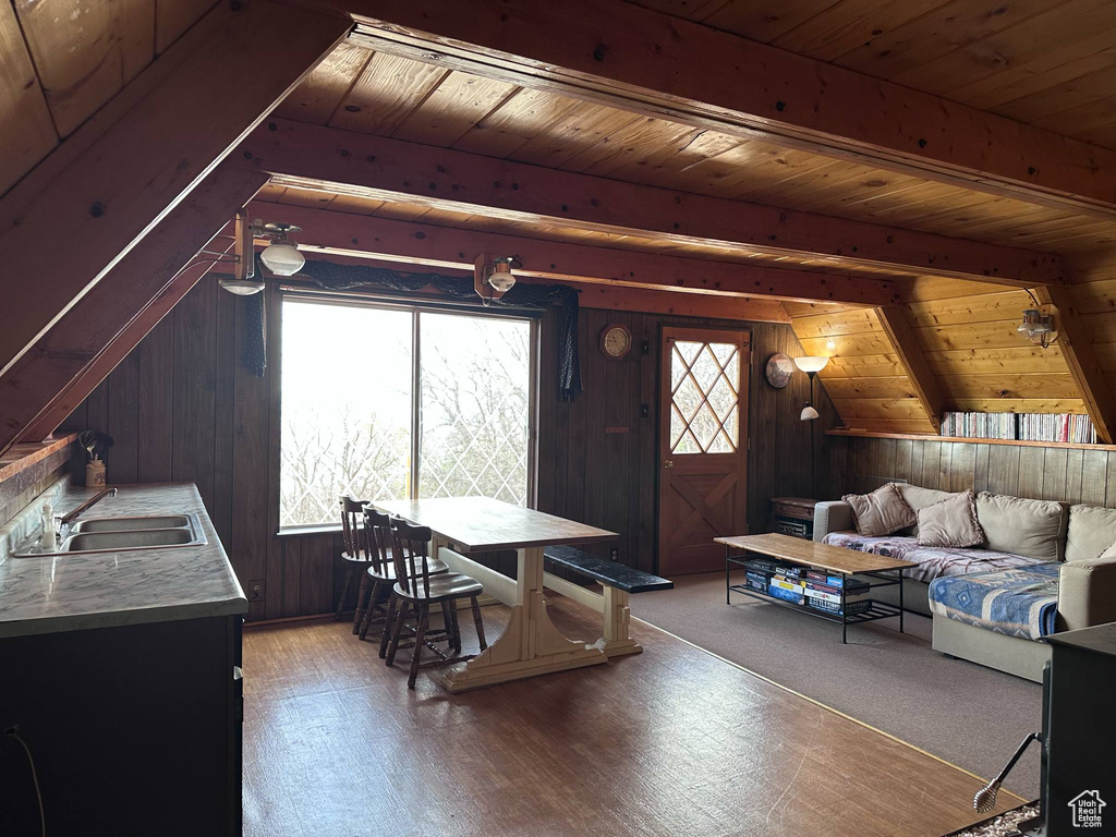 Living area with wood walls, wooden ceiling, and wood finished floors