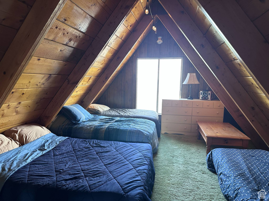Bedroom featuring carpet flooring, vaulted ceiling, wooden walls, and wood ceiling