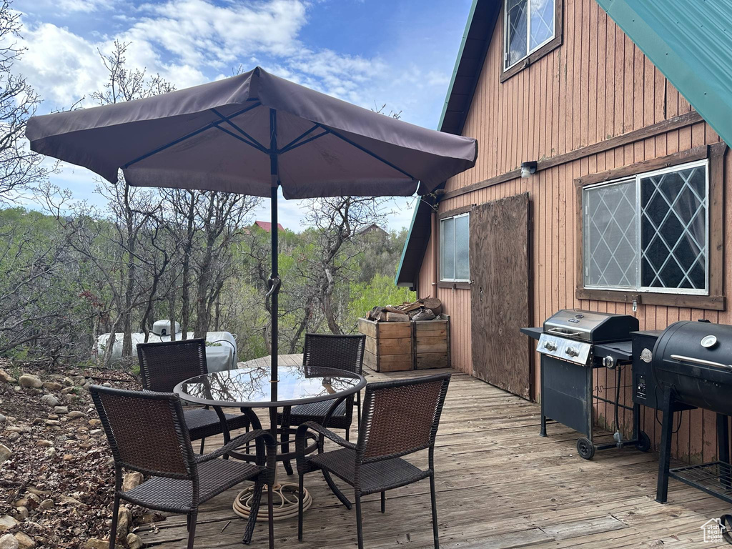 Wooden terrace with outdoor dining space and grilling area