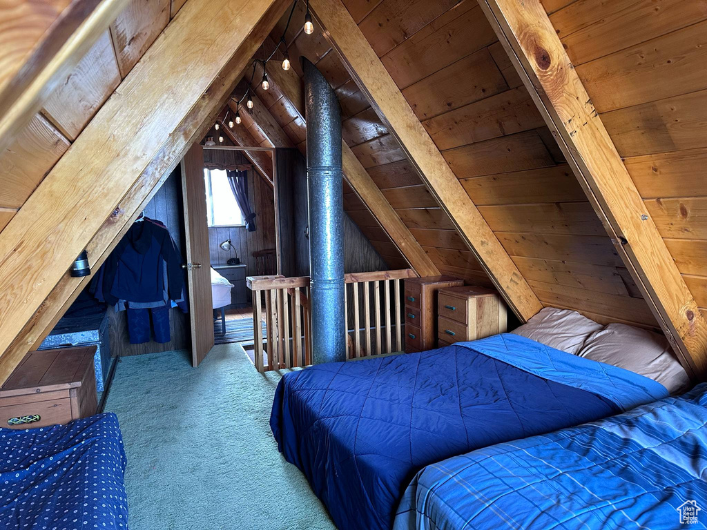 Bedroom featuring wood ceiling, wood walls, and carpet floors