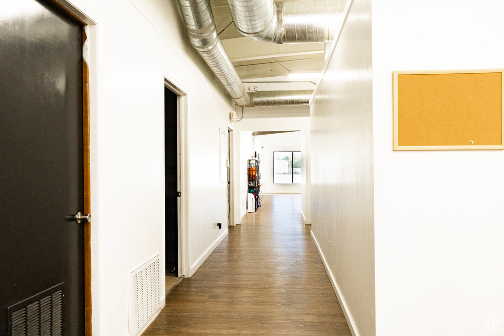 Corridor with wood finished floors and baseboards