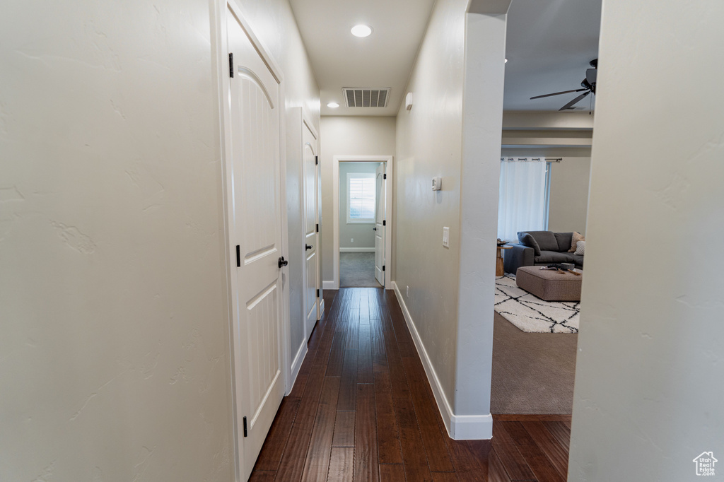 Corridor featuring dark wood-type flooring and baseboards