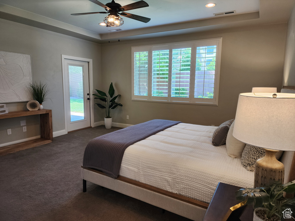 Carpeted bedroom featuring a tray ceiling, access to exterior, baseboards, recessed lighting, and a ceiling fan