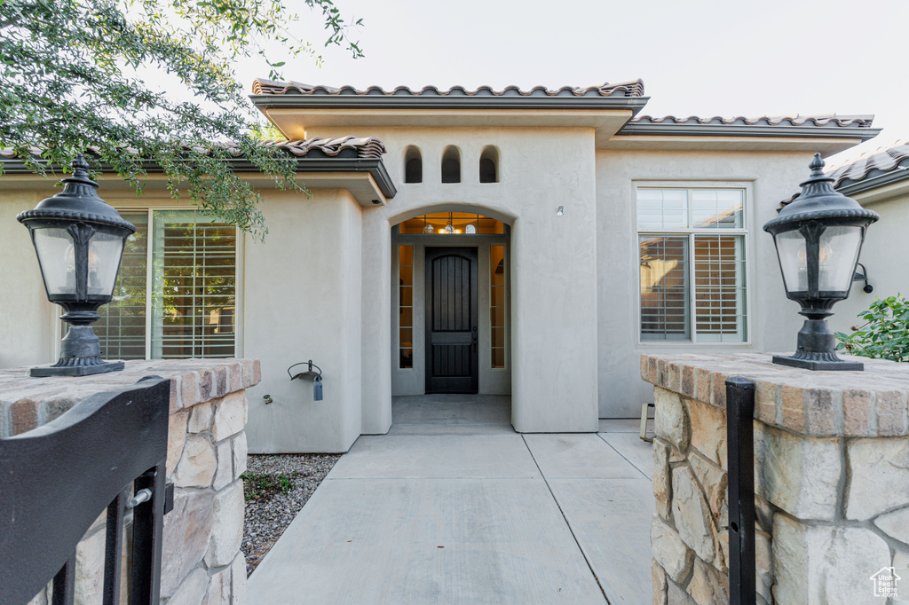 View of exterior entry featuring stucco siding and a tiled roof