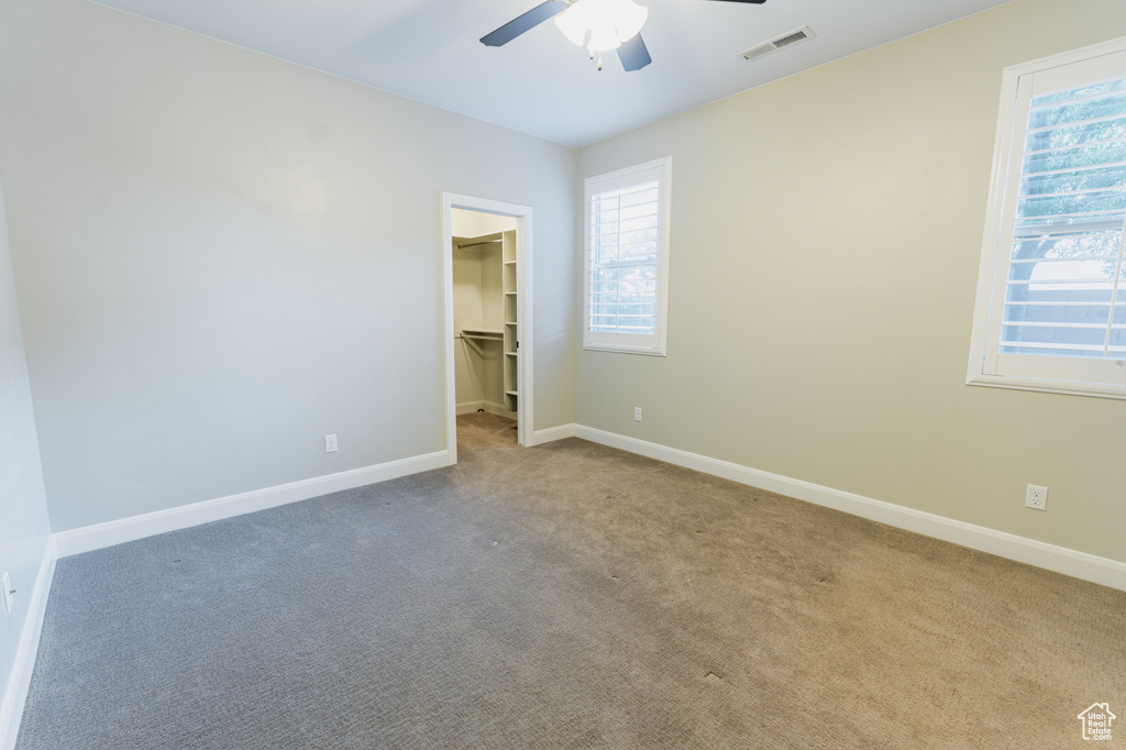 Unfurnished bedroom featuring multiple windows, carpet flooring, and baseboards