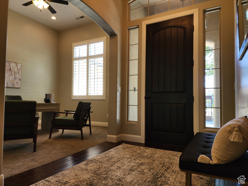 Foyer entrance with dark wood-style flooring, ceiling fan, and baseboards