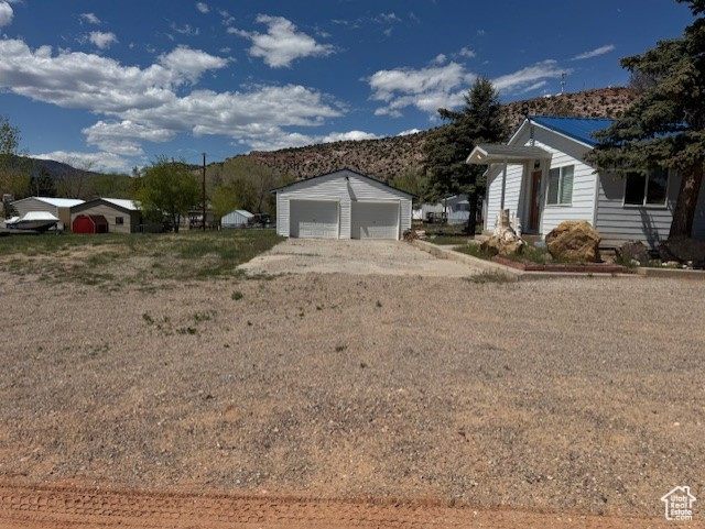 View of side of property featuring a mountain view, a garage, and an outdoor structure