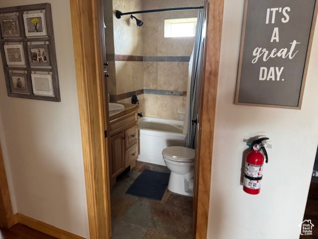 Full bathroom featuring toilet, vanity, and shower / bath combo with shower curtain