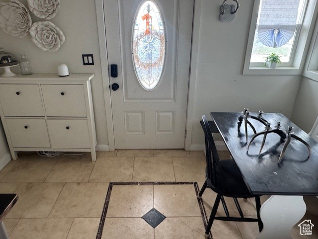 Entrance foyer with light tile patterned floors and baseboards