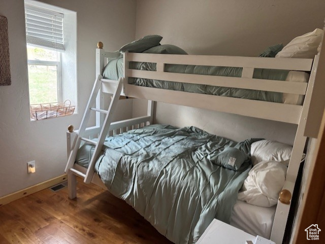 Bedroom featuring wood finished floors and baseboards