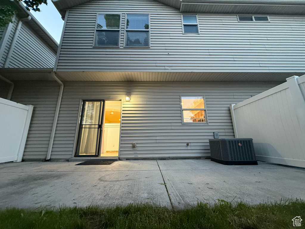 Back of property featuring central air condition unit and a patio