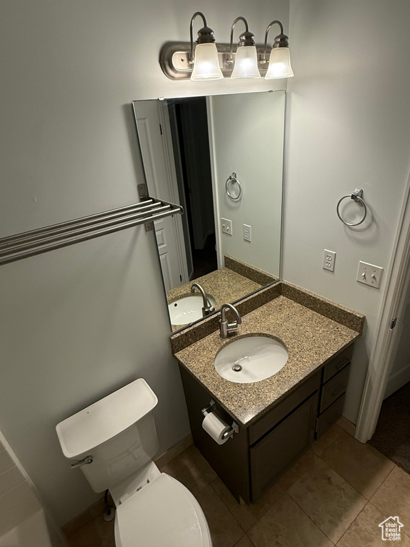Bathroom featuring vanity, toilet, and tile patterned floors