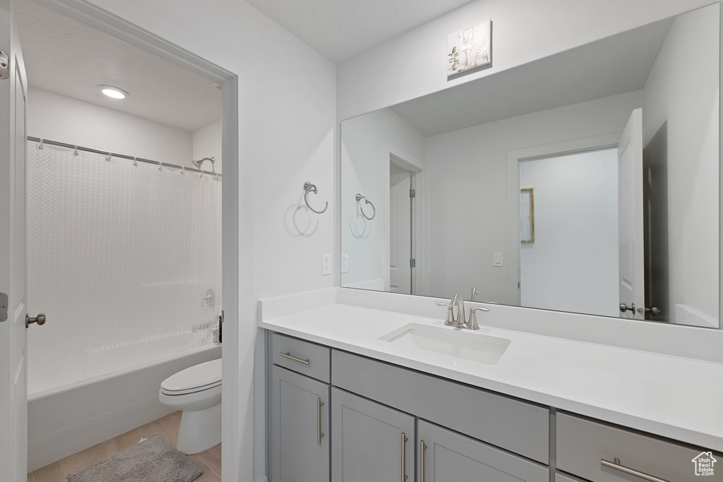 Bathroom with toilet, vanity, and shower / tub combo with curtain