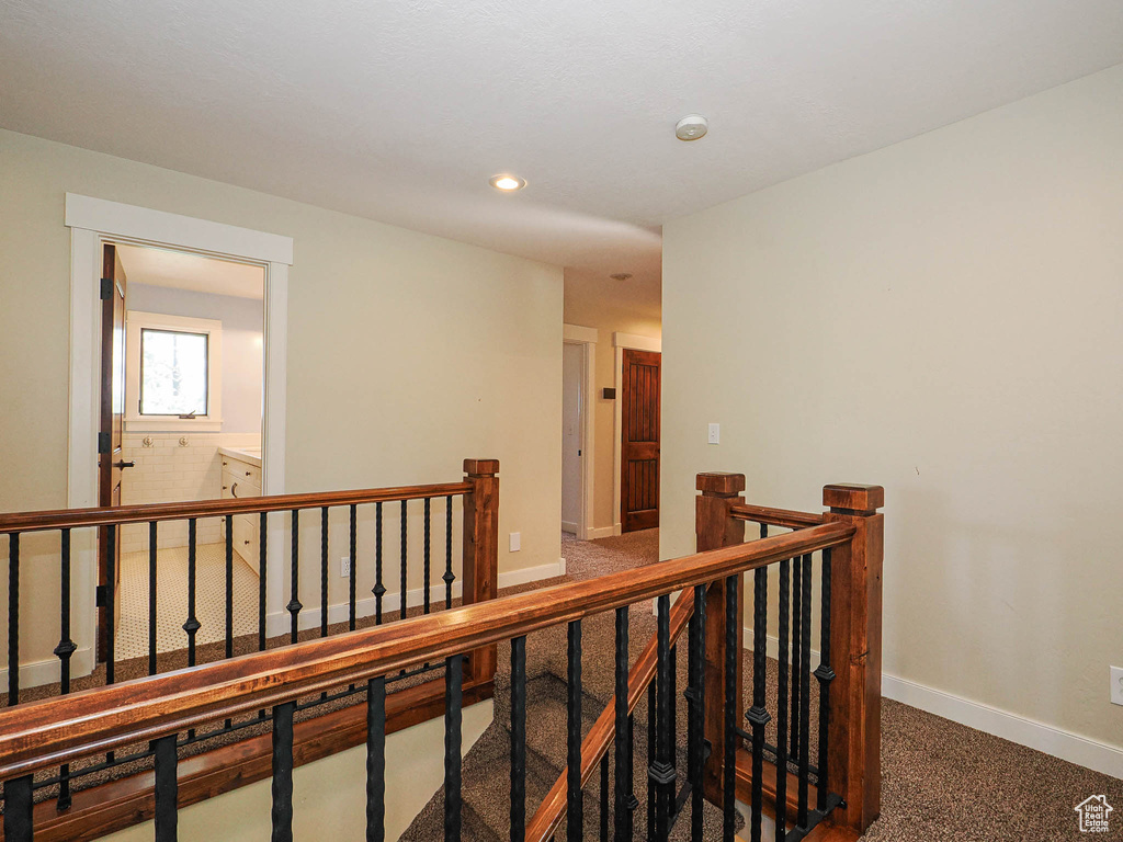 Hallway with an upstairs landing, baseboards, carpet flooring, and recessed lighting