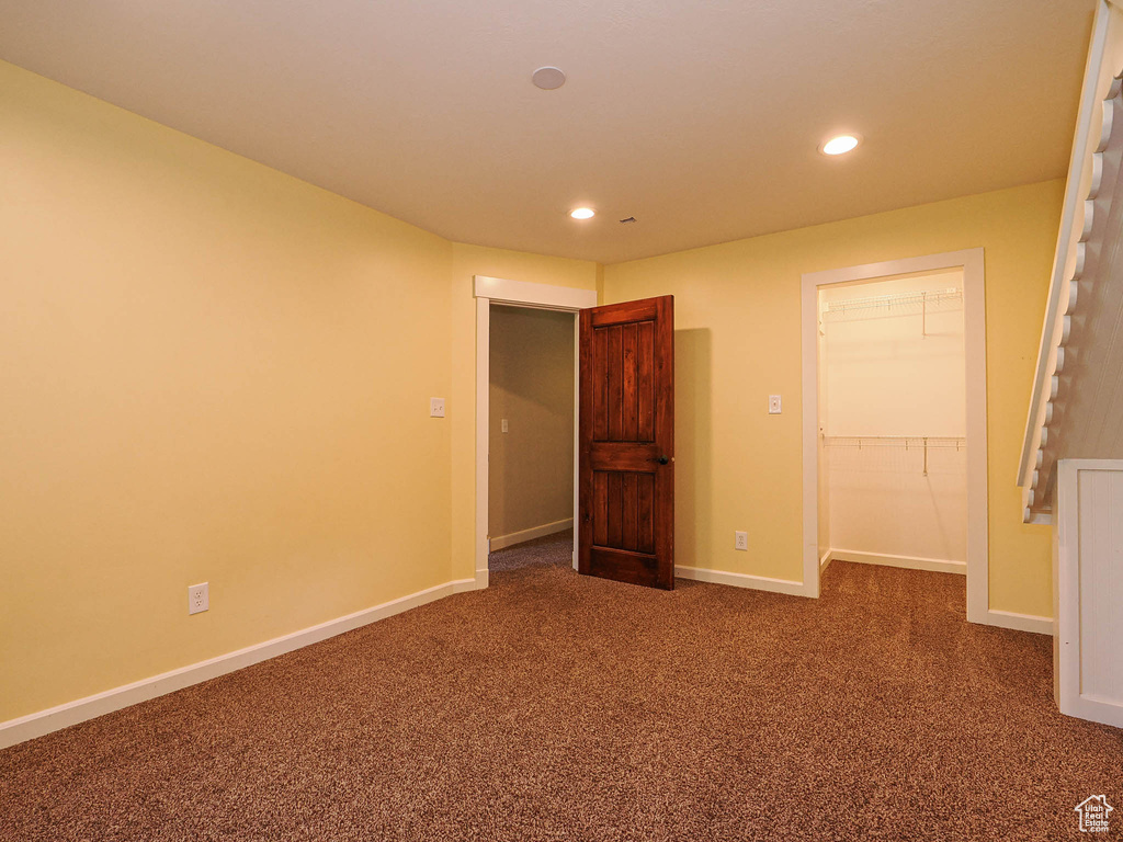 Unfurnished bedroom with recessed lighting, carpet flooring, a walk in closet, baseboards, and a closet