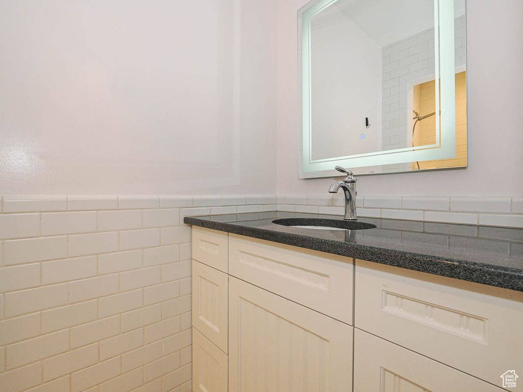 Bathroom featuring vanity and tile walls