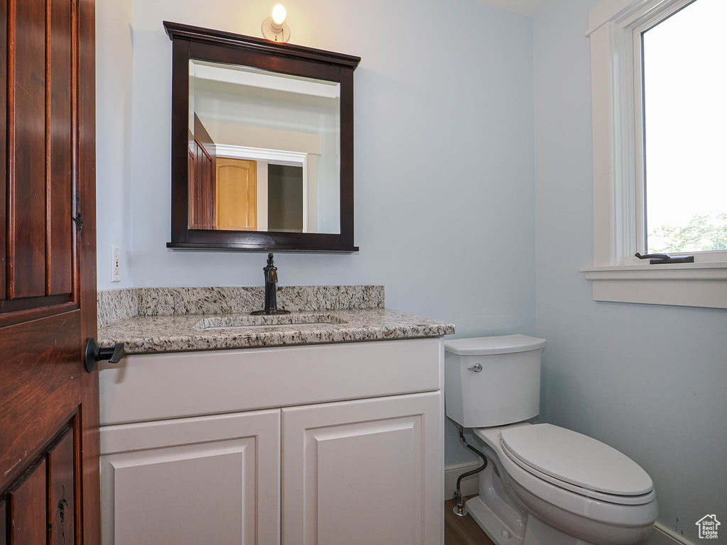 Bathroom featuring toilet, vanity, and baseboards