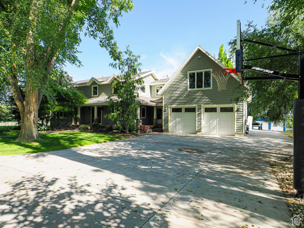 View of front facade with an attached garage, concrete driveway, and a front lawn