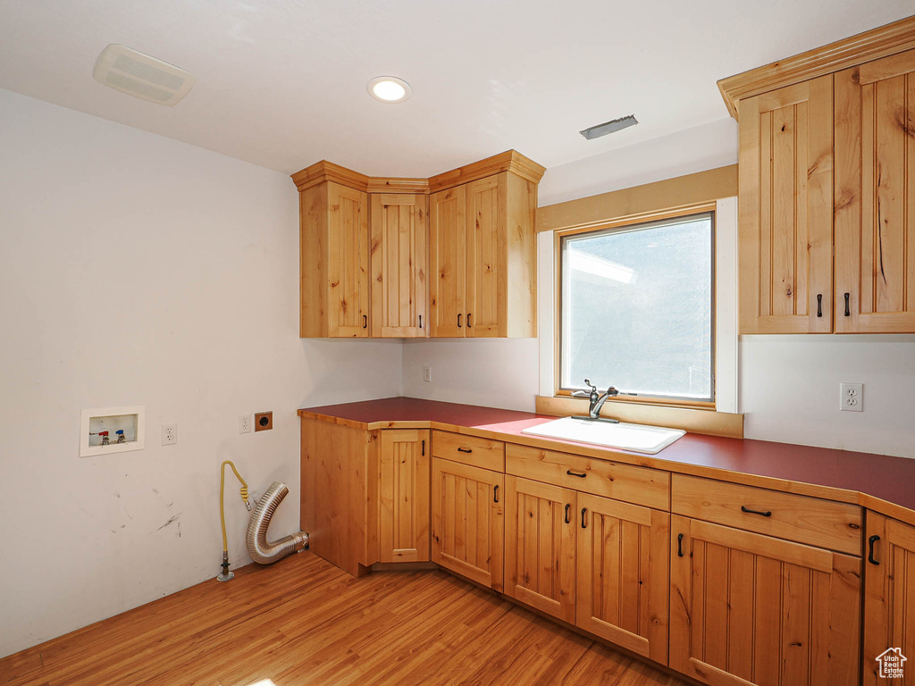 Laundry area featuring hookup for a washing machine, cabinet space, light wood-style flooring, electric dryer hookup, and recessed lighting