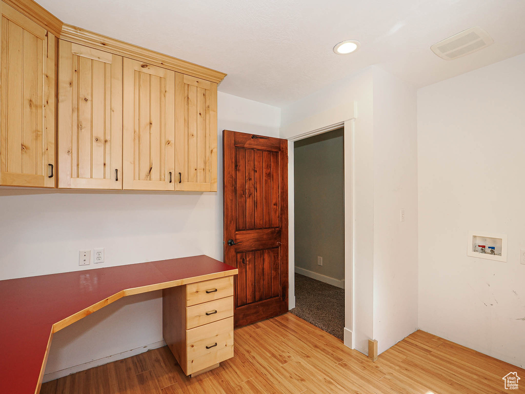 Unfurnished office with light wood-style floors, recessed lighting, and built in desk