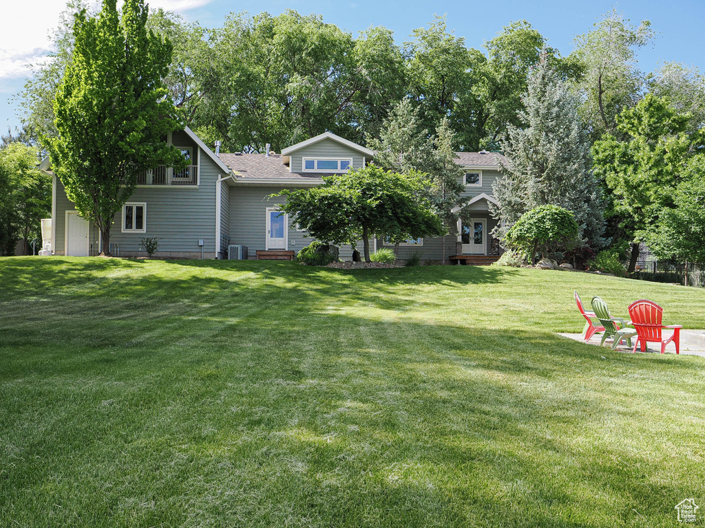 View of grassy yard with central air condition unit