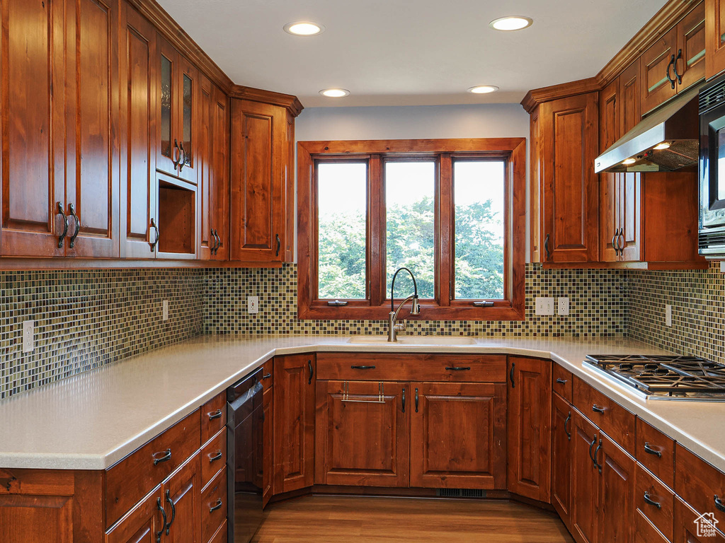 Kitchen featuring a sink, dishwasher, light wood-style flooring, recessed lighting, and light countertops