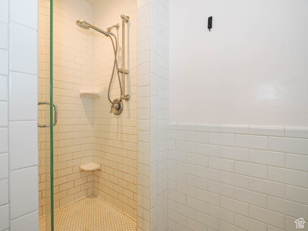 Bathroom featuring a shower stall and wainscoting