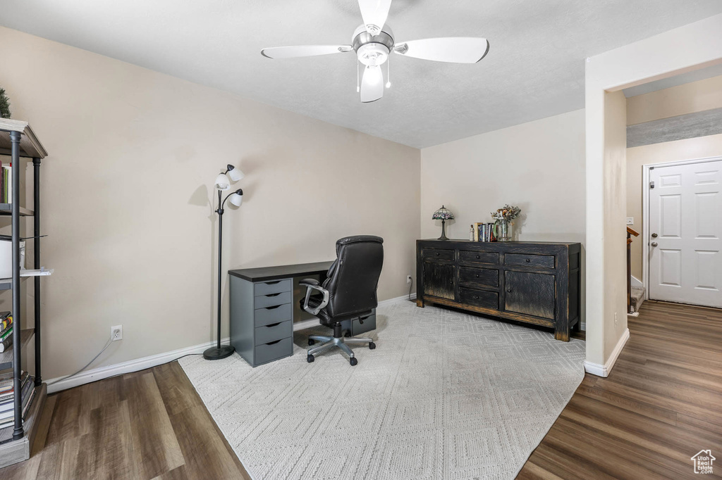 Home office with wood finished floors, ceiling fan, and baseboards
