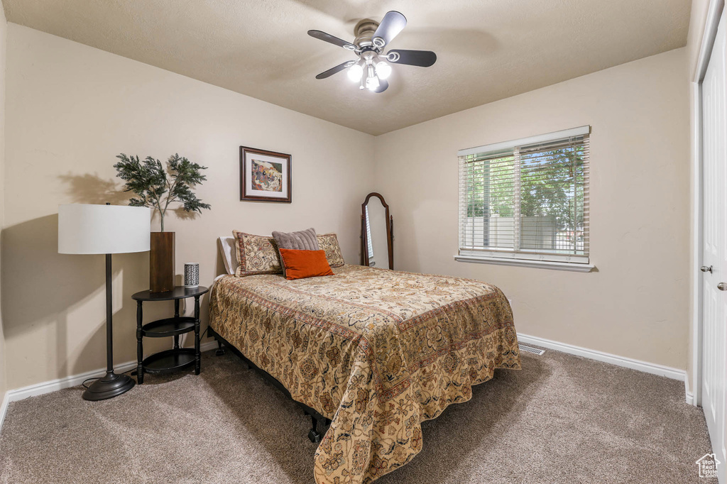 Carpeted bedroom with baseboards and ceiling fan