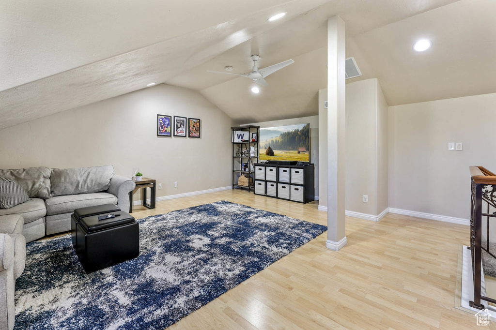 Living room with vaulted ceiling, wood finished floors, baseboards, a ceiling fan, and recessed lighting