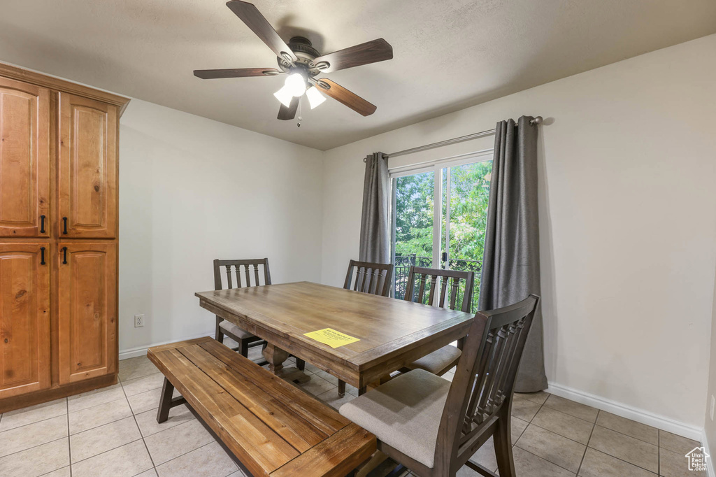 Dining area featuring light tile patterned floors, baseboards, and a ceiling fan
