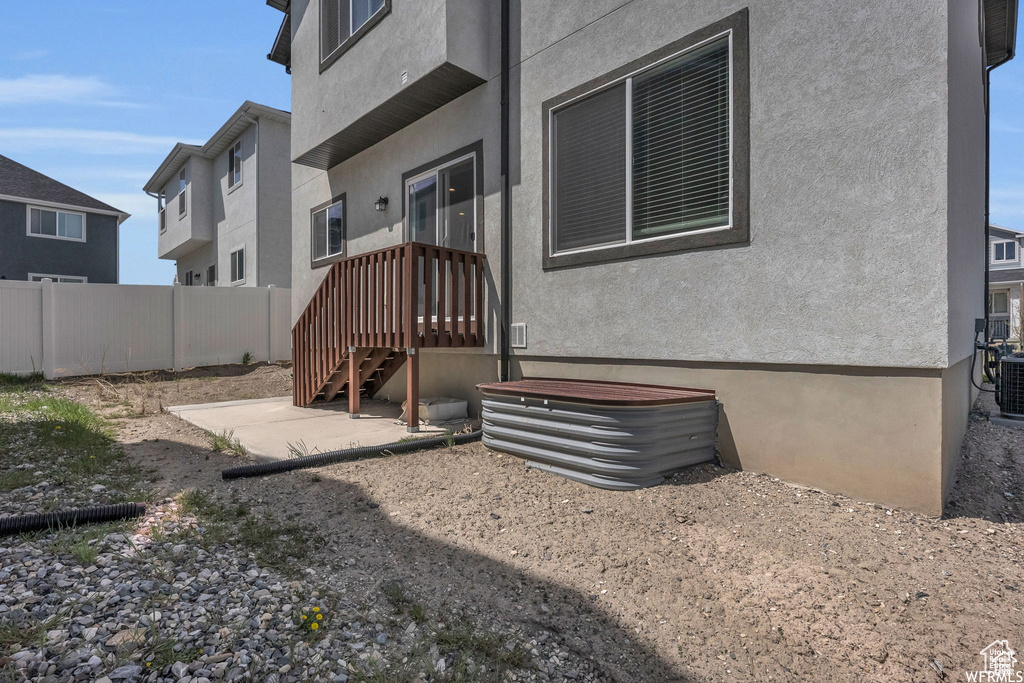 Back of house with stucco siding and central AC