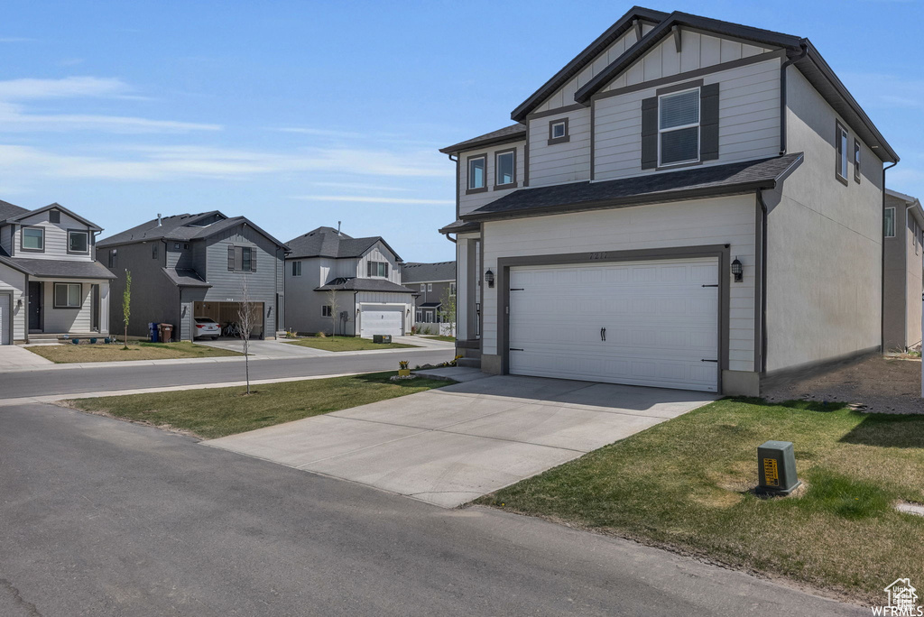 View of front of home featuring a residential view, an attached garage, concrete driveway, and board and batten siding