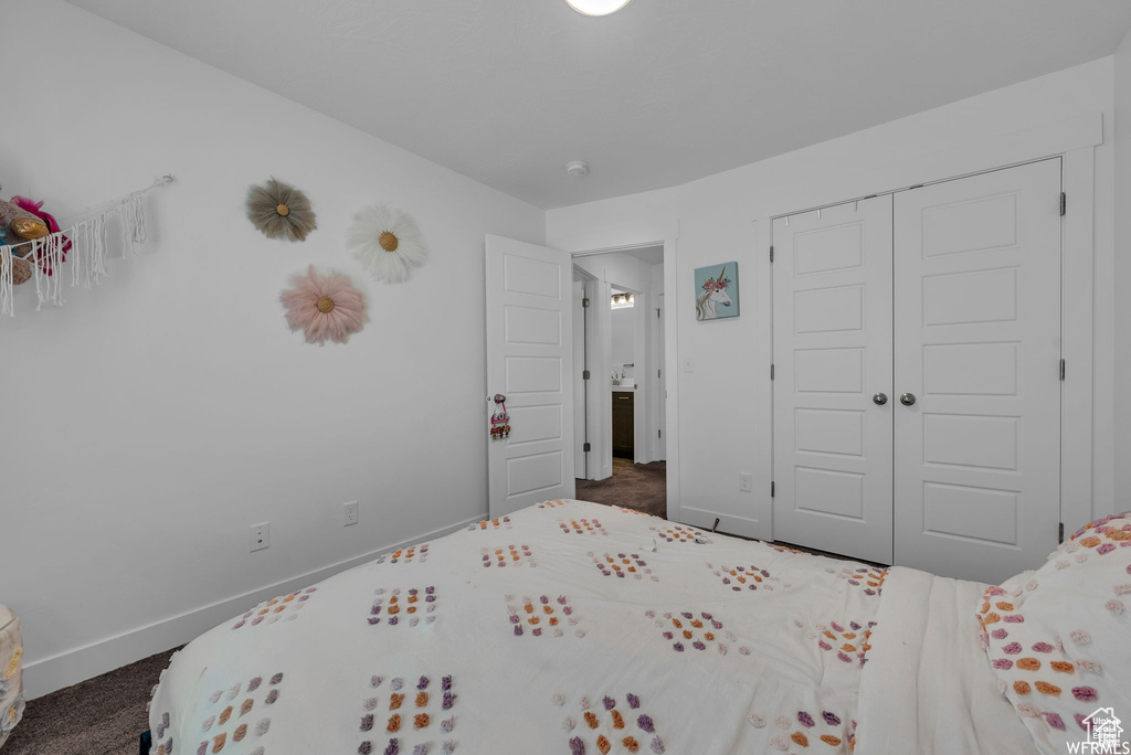 Bedroom featuring baseboards, a closet, and dark carpet