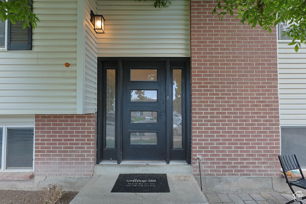 View of exterior entry with brick siding