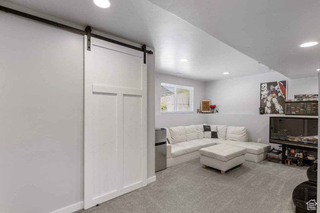Living room featuring a barn door, carpet, recessed lighting, and baseboards